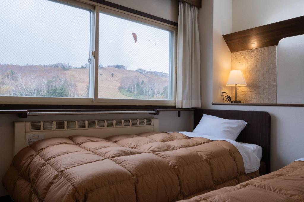 Postel nebo postele na pokoji v ubytování Shiga Kogen Olympic Hotel