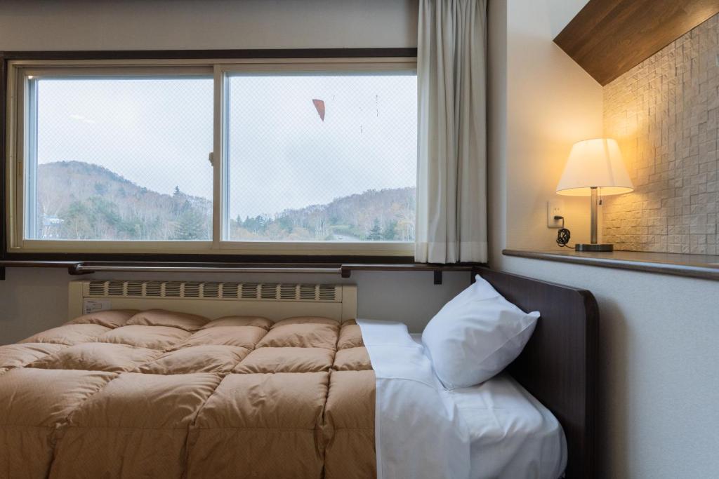 Postel nebo postele na pokoji v ubytování Shiga Kogen Olympic Hotel