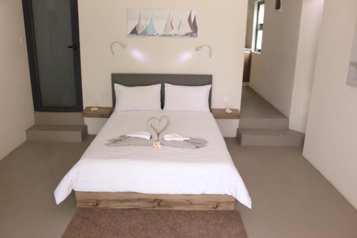 トゥルー・ドー・ドゥースにあるValmarin Seafront Apartmentsの天使の羽が付いた白いベッドのある寝室