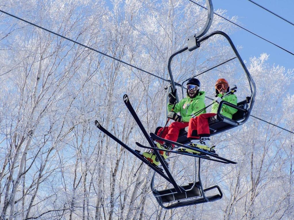 dwie osoby jeżdżące wyciągiem narciarskim w obiekcie Shiga Kogen Olympic Hotel w mieście Yamanouchi