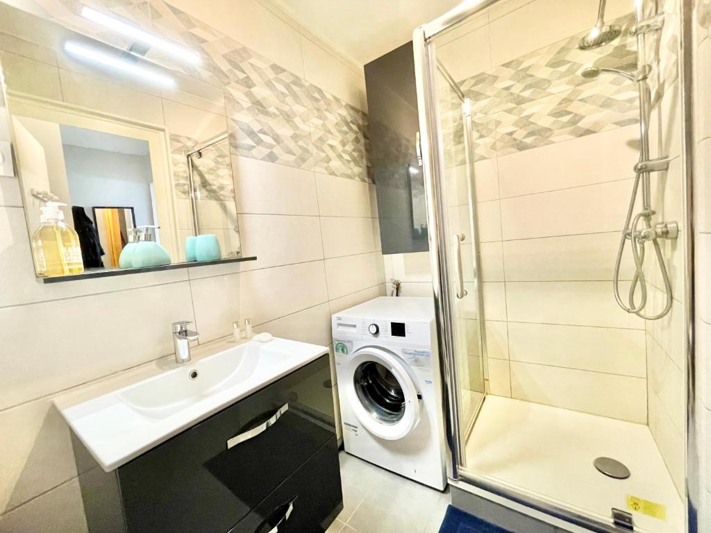 a bathroom with a sink and a washing machine at Saint Nazaire - Le Sembat - Proche mer - Wifi fibre in Saint-Nazaire
