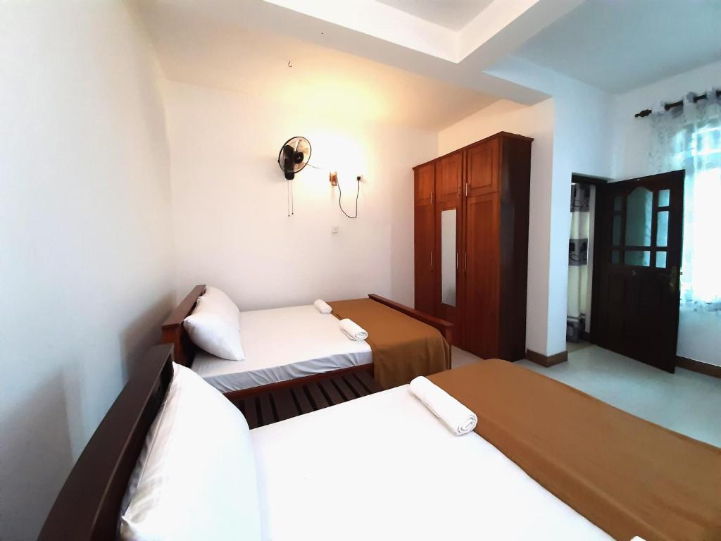 a bedroom with two beds and a window at RIDGEMONT VILLA in Kandy