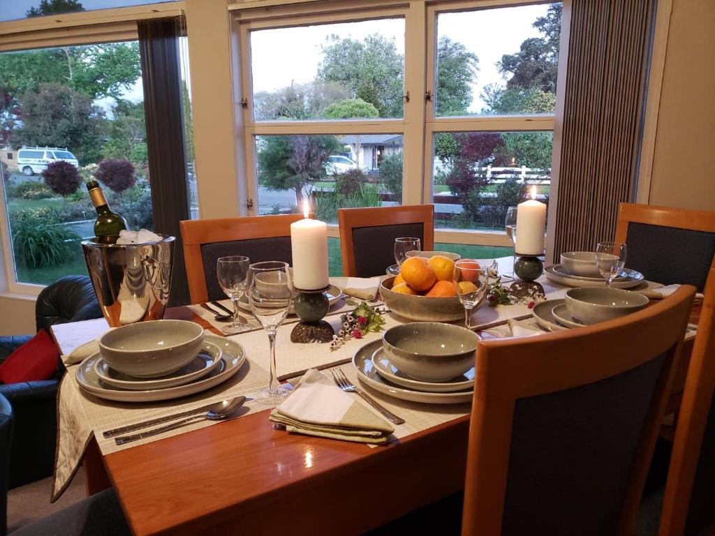 einem Esstisch mit Kerzen und einem Tisch mit Essen in der Unterkunft Quiet cul de sac, close to Abel Tasman in Motueka