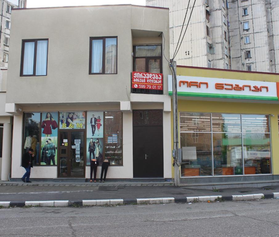 a building on a city street with people standing outside at Hotel Nikea in Kutaisi