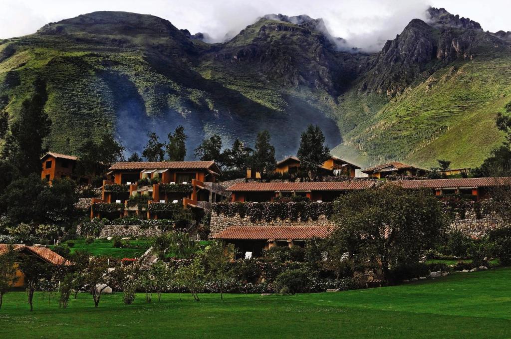 un gruppo di edifici di fronte a una montagna di Rio Sagrado, A Belmond Hotel, Sacred Valley a Urubamba