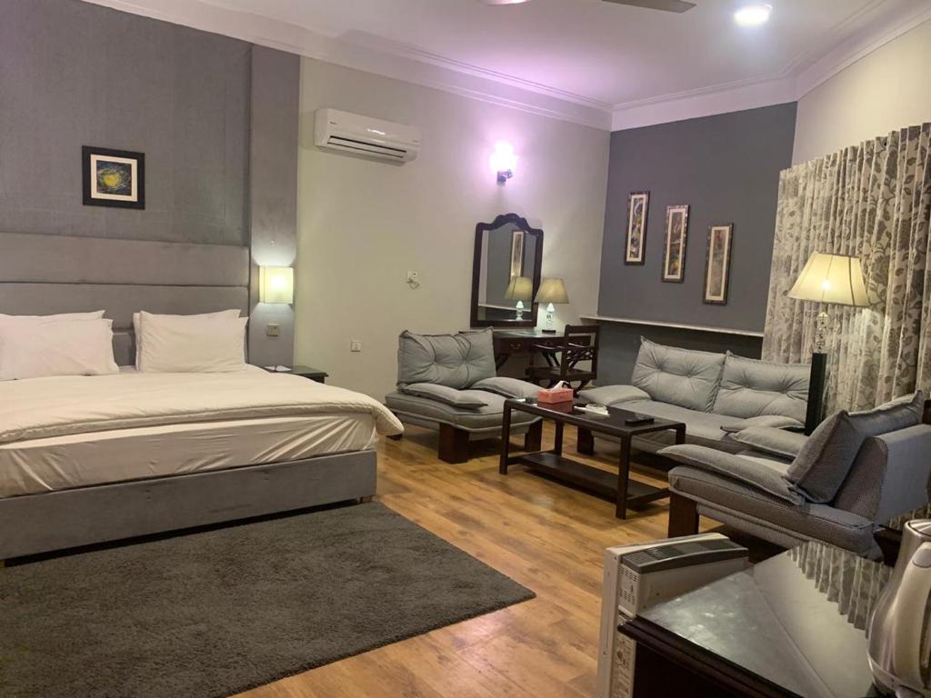um quarto com uma cama e uma sala de estar em The Exclusive House em Peshawar