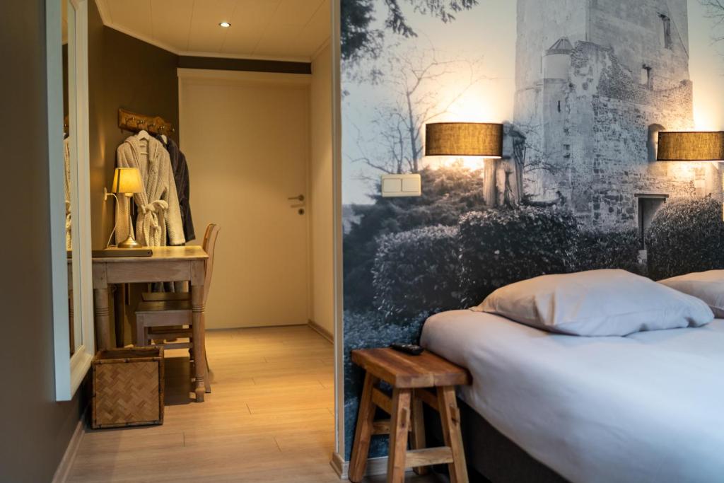 um quarto com uma cama, uma mesa e uma secretária em Hotel De Maretak em Dilsen-Stokkem