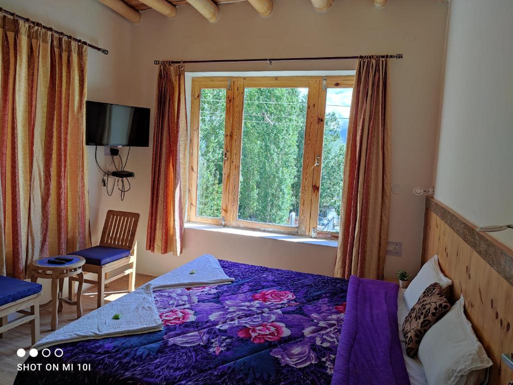 a bedroom with a bed and a window at The Mir Villa Ladakh in Leh