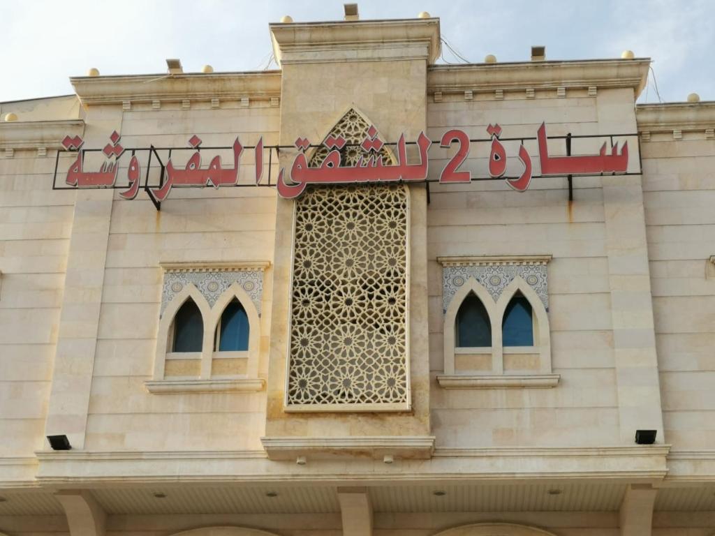 um edifício com um sinal na lateral em سارة للشقق المفروشة - الحمدانية جدة em Ḩayy aş Şāliḩīyah