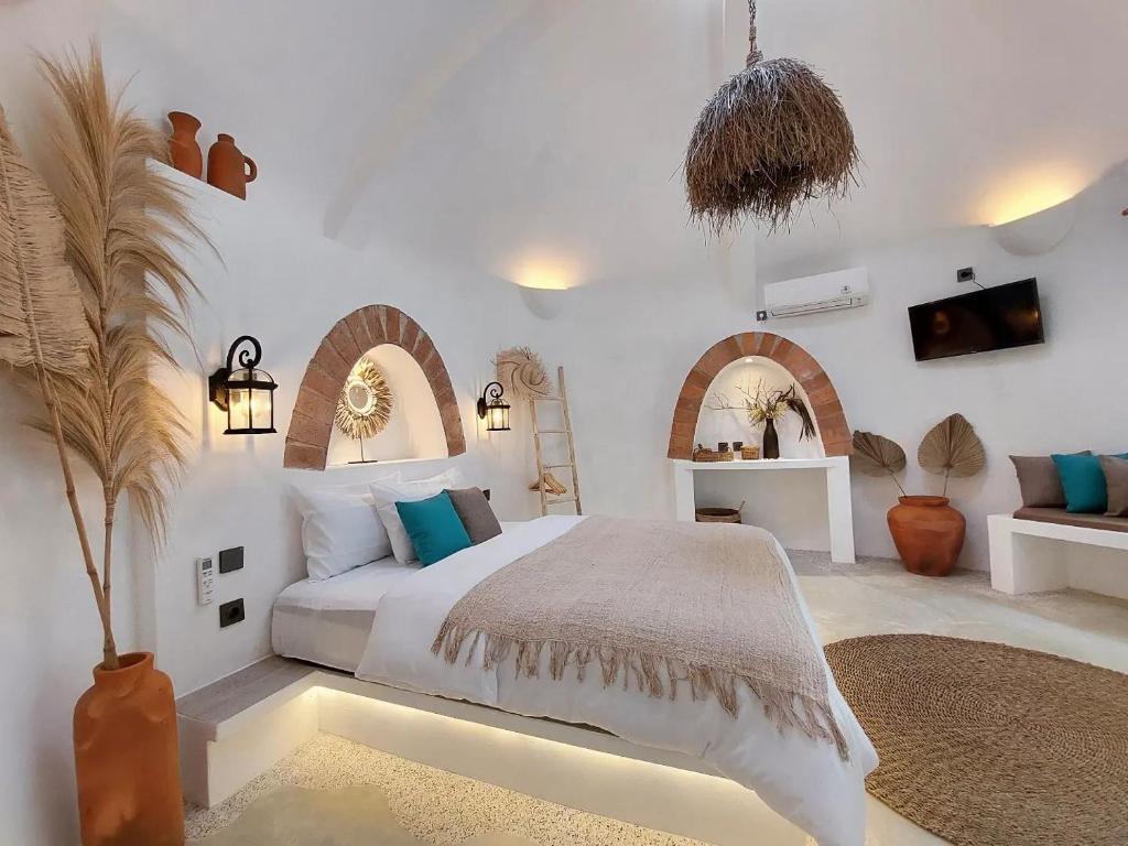 a white bedroom with a bed and a couch at OMA WATU DOME VILLAS in Pacitan