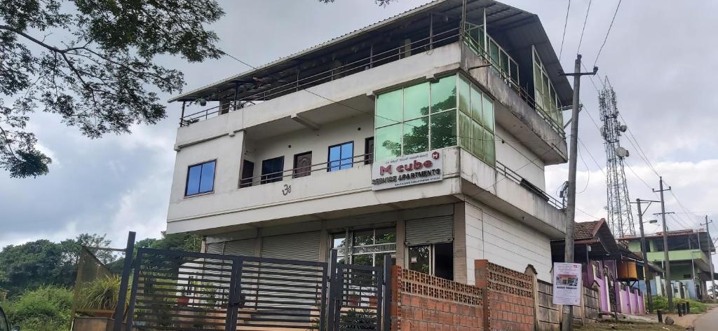 a building with a sign on the side of it at M Cube Service Apartments in Sakleshpur