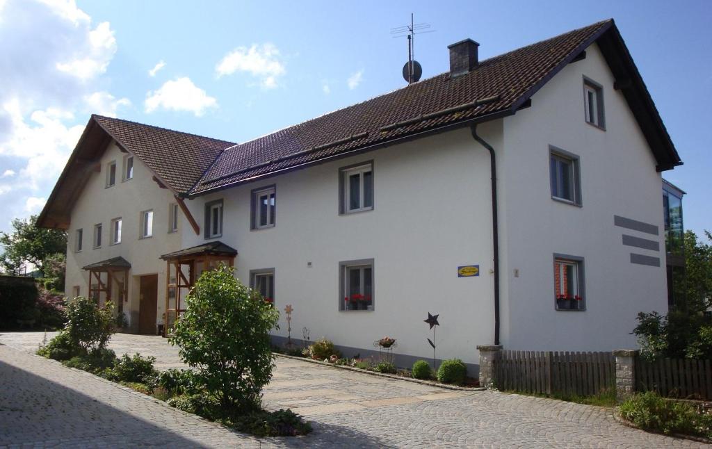 ein großes weißes Gebäude mit braunem Dach in der Unterkunft Ferienhaus Stockinger in Jandelsbrunn