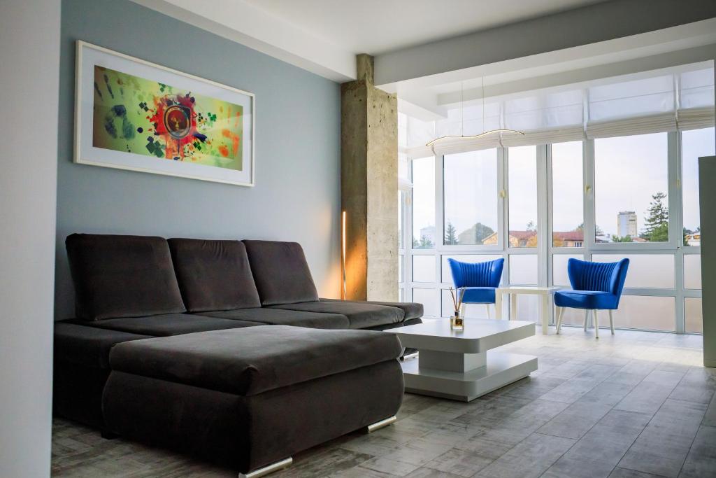 a living room with a couch and blue chairs at Central Bliss in Suceava