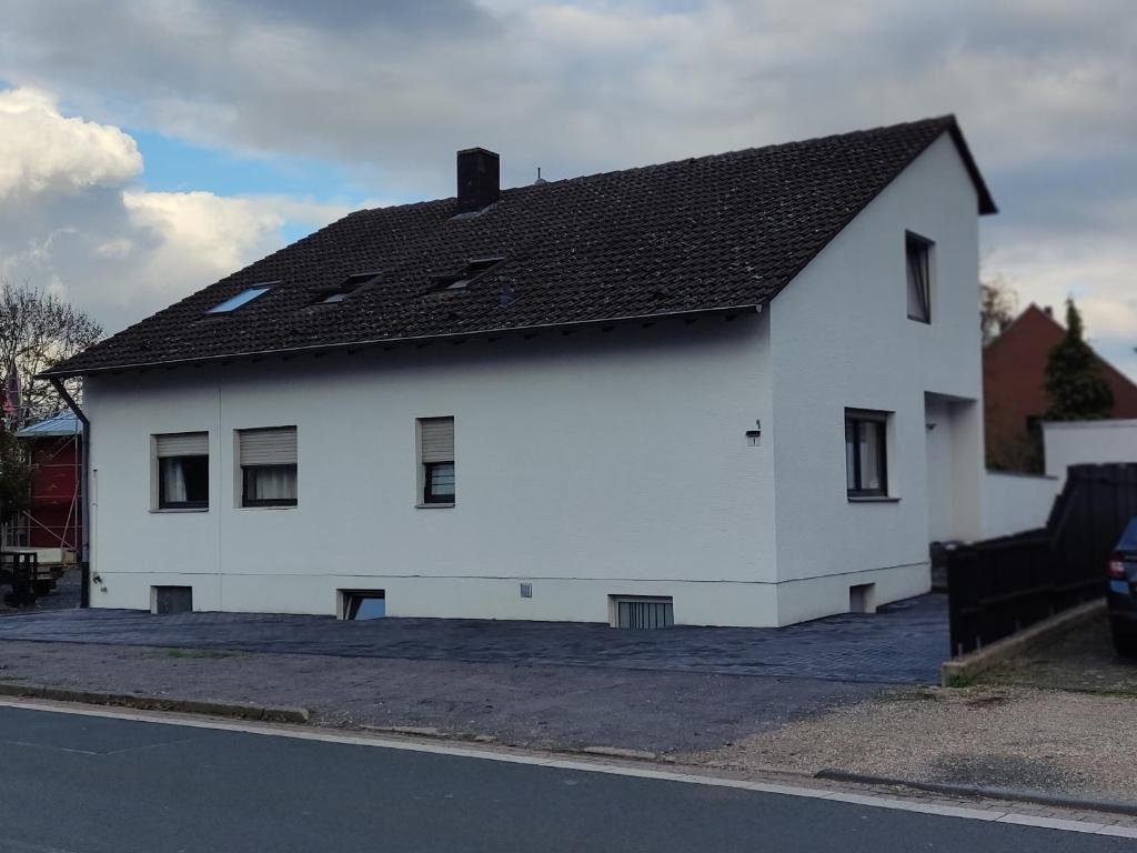 a white house with a black roof on a street at Ferienwohnung in Erftstadt in Erftstadt