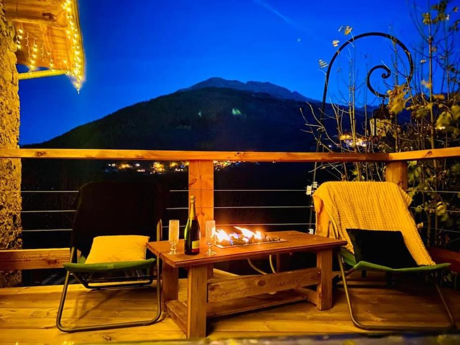 a table and chairs on a deck with a view of a mountain at Chalet au cœur de la montagne in Valmeinier