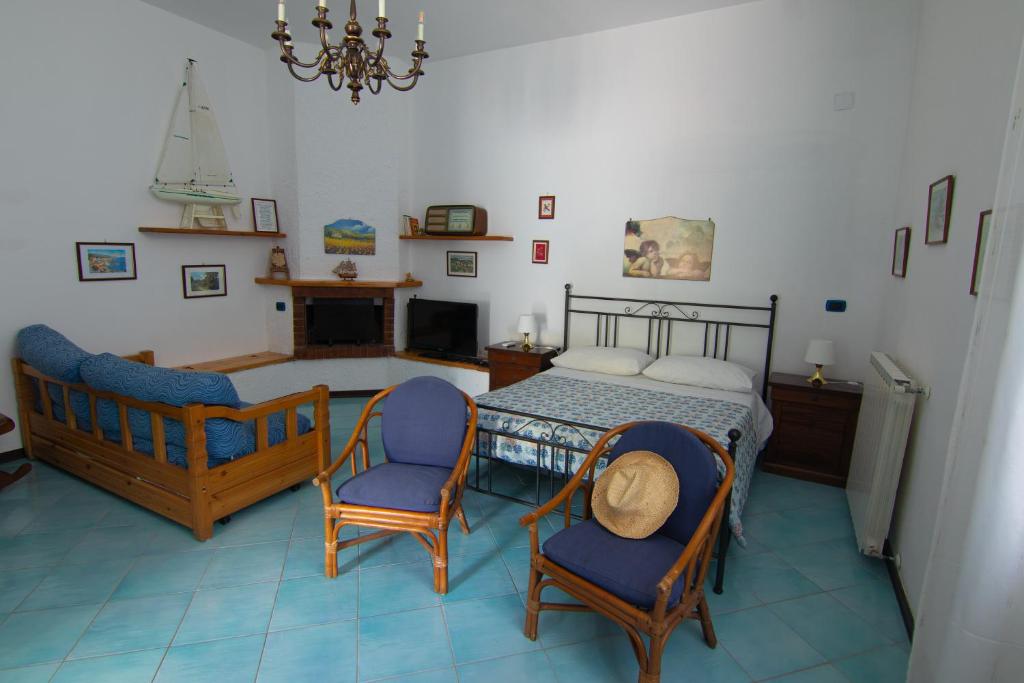 1 Schlafzimmer mit einem Bett und 2 Stühlen in der Unterkunft Ponza Holiday Homes - Santa Maria in Ponza