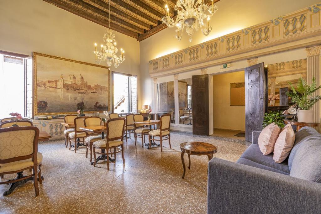 salon ze stołami, krzesłami i obrazem w obiekcie Residenza Centopietre - Dorsoduro by Wonderful Italy w Wenecji