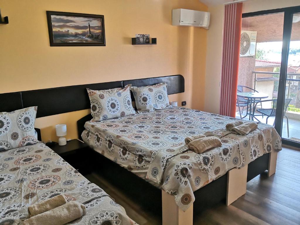 a bedroom with two beds and a balcony at Морската Къща in Tsarevo