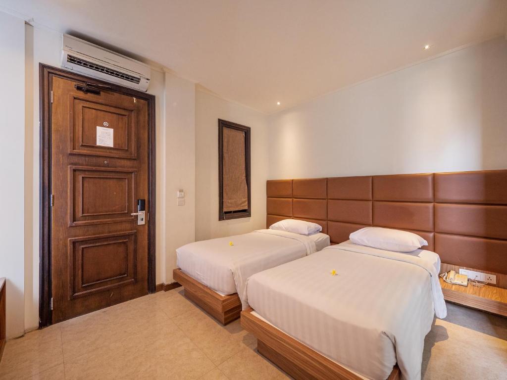 Postel nebo postele na pokoji v ubytování Alron Hotel Kuta