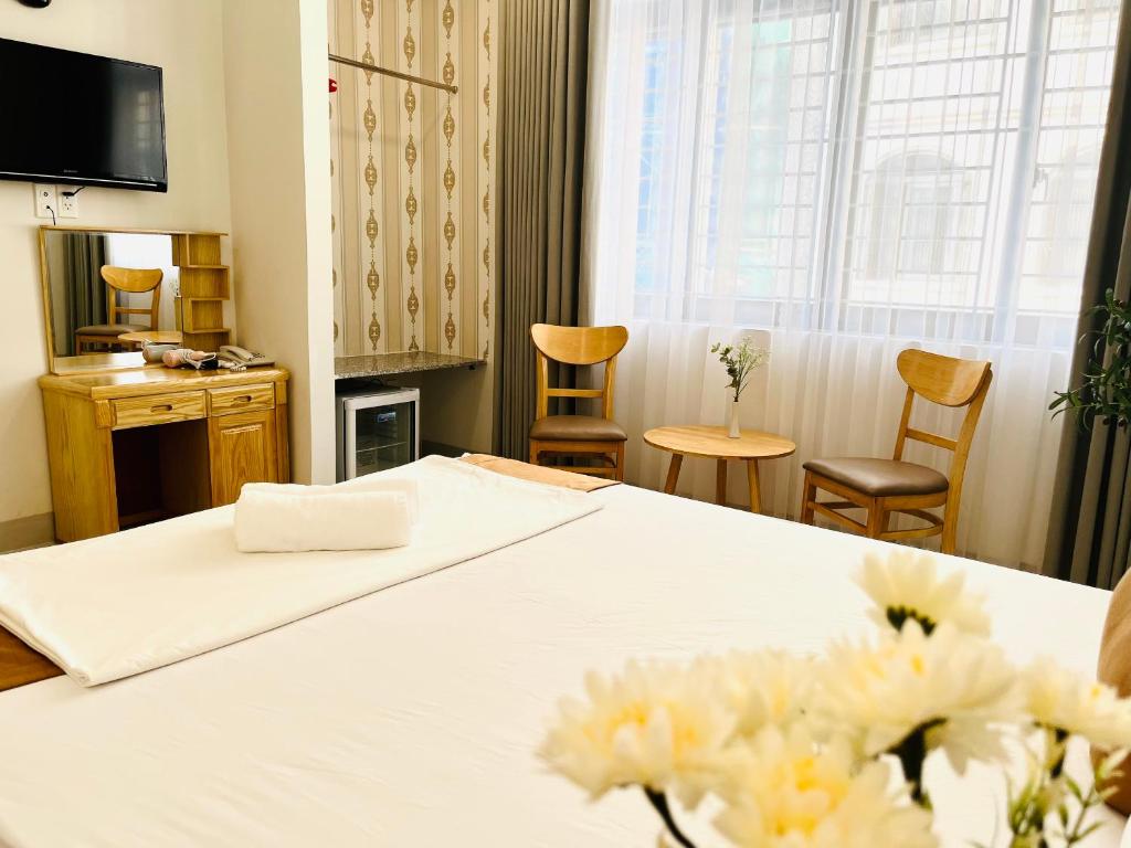 a hotel room with a bed with flowers on it at Anh Đào Hotel in Vung Tau