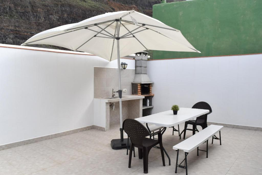 een witte tafel en stoelen met een parasol bij Casa Sabare in Guinea