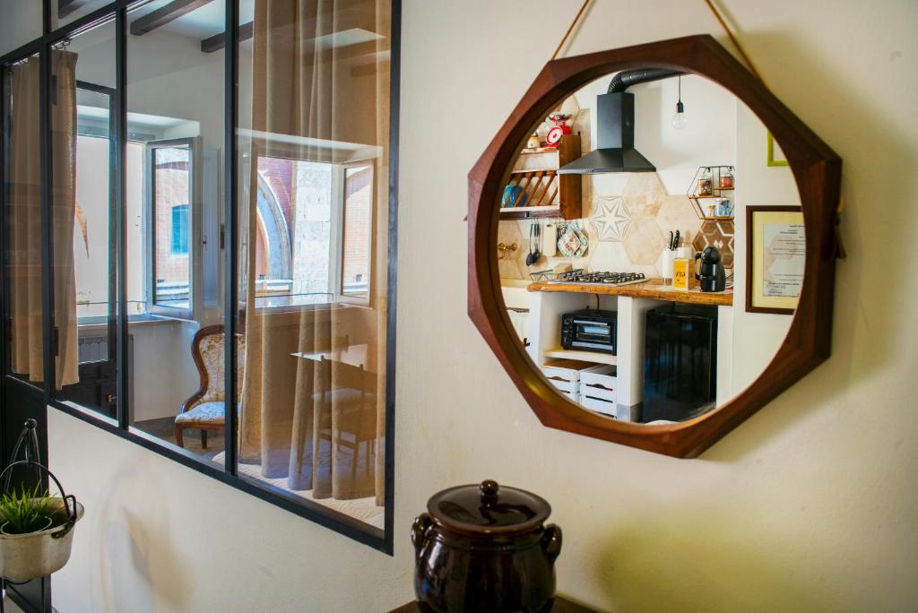 um espelho pendurado numa parede ao lado de uma cozinha em ManillaHouse em Montepulciano