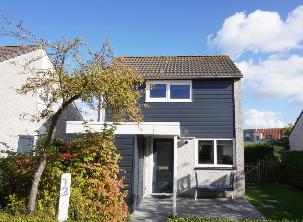 a house with a black and white exterior at Vakantiehuis Grevelingen 12 aan Grevelingenmeer. nabij Port Greve in Brouwershaven