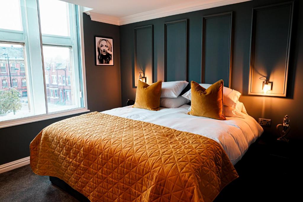 a bedroom with a large bed and two windows at The Old Post Office Warrington by Deuce Hotels in Warrington