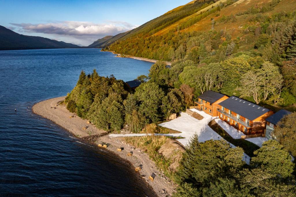 an aerial view of a house on the shore of a lake at Black Sheep Hotels Cabins in Spean Bridge