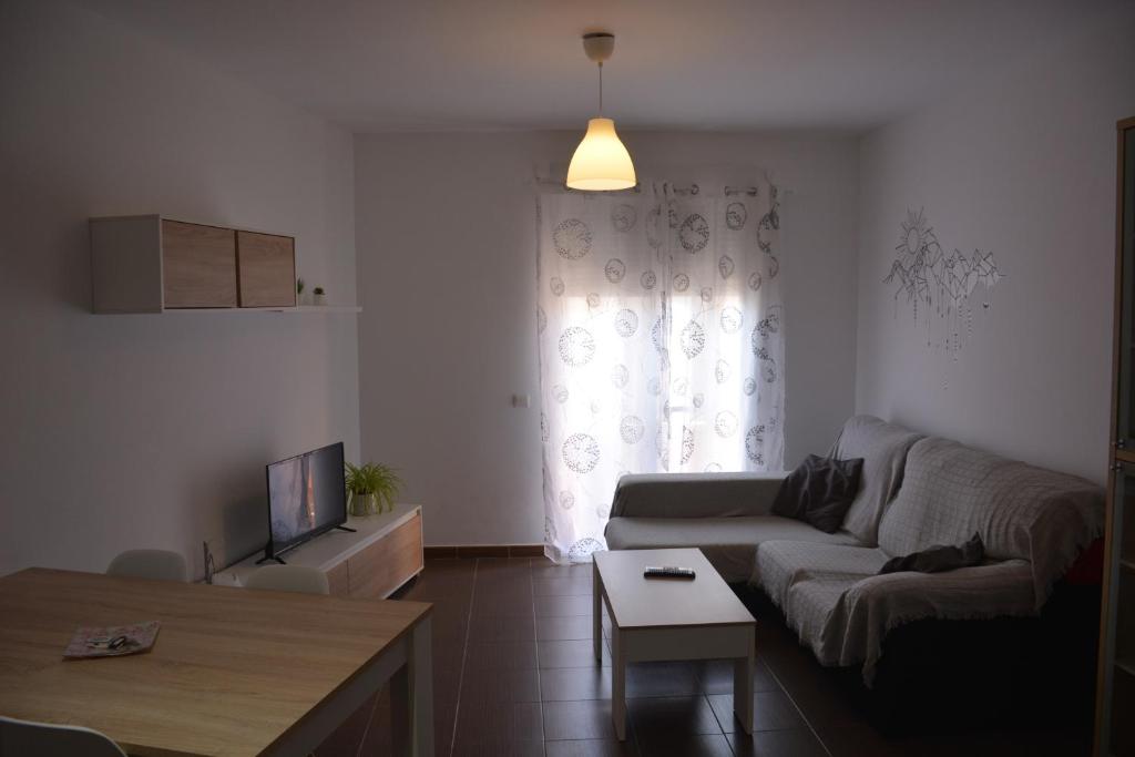 sala de estar con sofá y TV en Apartamento14 Ruidera AguaPlacer, en Ruidera