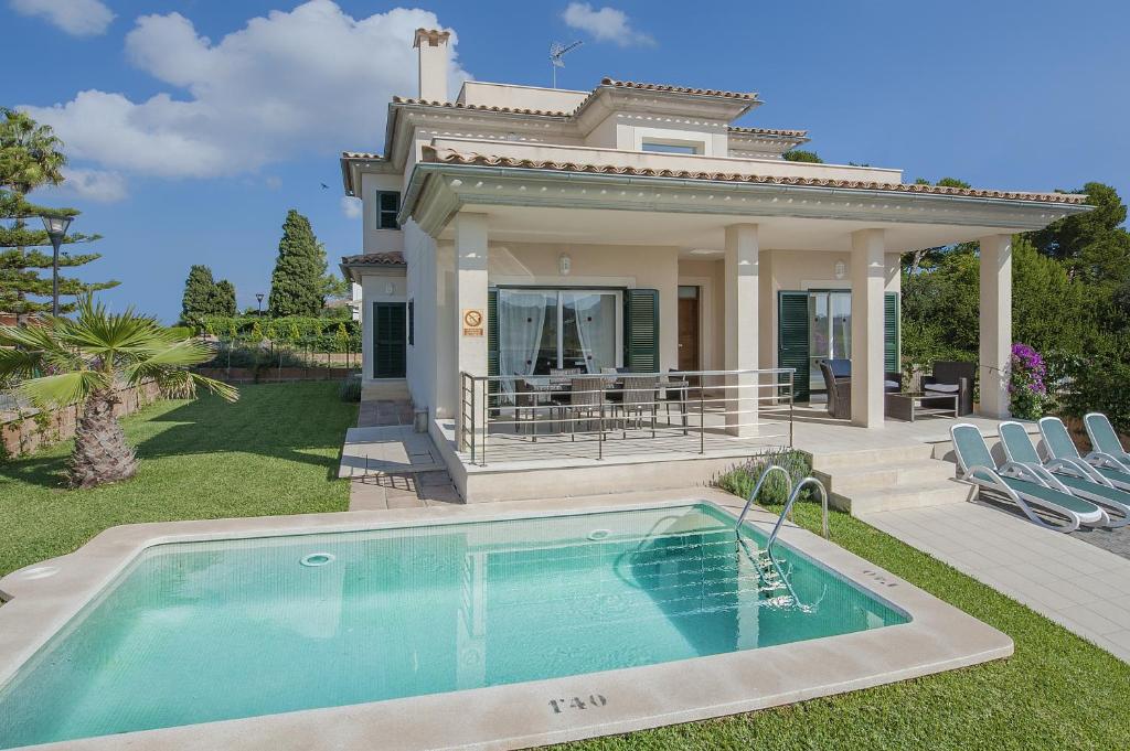 una casa con piscina frente a una casa en Villa Marisa I, en Alcudia