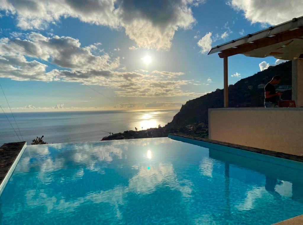 a swimming pool with a view of the ocean at Villa Escola da Bica in Arco da Calheta