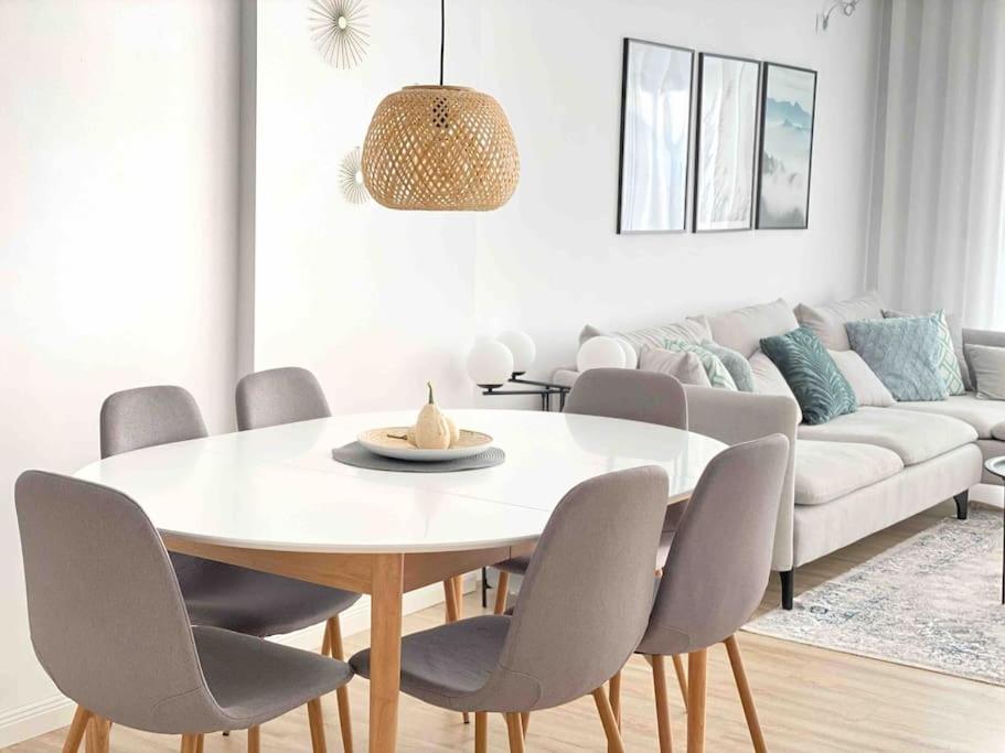 a dining room with a white table and chairs at RONI APARTMENTS -Near the historic city center -Family-friendly -Baby cots and toys available -Netflix -Convenient for sightseeing -Services available -Free parking with video surveillance in Prizren