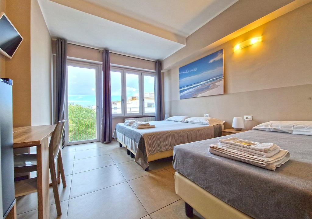 サッサリにあるB&B Viale San Pietroのベッド2台と窓が備わるホテルルームです。
