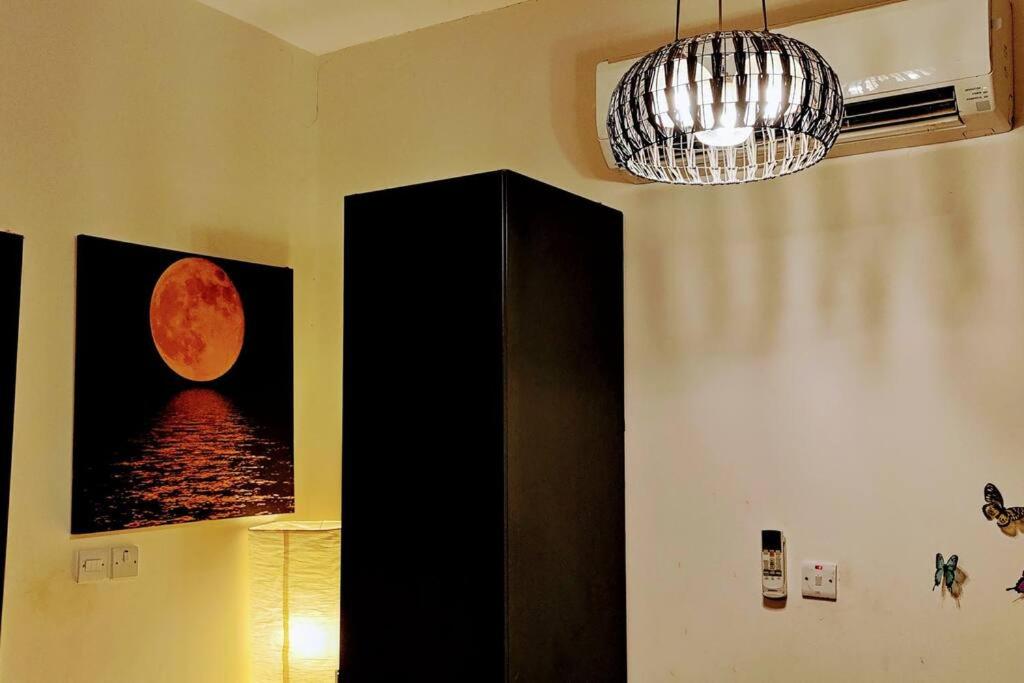 a room with a painting of a moon on the wall at Full Apartment in Central Al Ain (All Amenities) in Al Ain