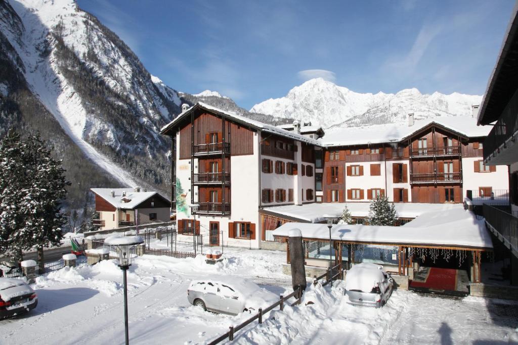 un hotel en la nieve con montañas en el fondo en Hotel Alpechiara, en Pré-Saint-Didier