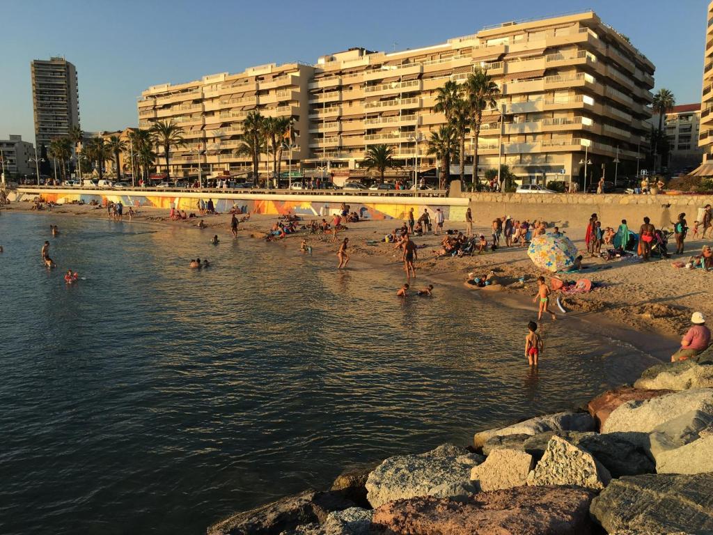 eine Gruppe von Menschen an einem Strand in der Nähe des Wassers in der Unterkunft T2 de 55m2 tout confort en bord de mer in Saint-Raphaël