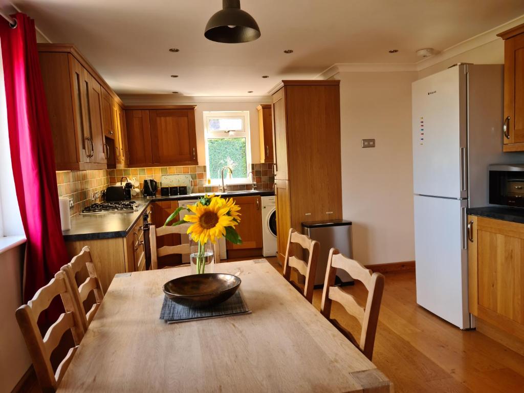 a kitchen with a wooden table with a vase on it at Rural escape with countryside views & Log burner in Coddenham