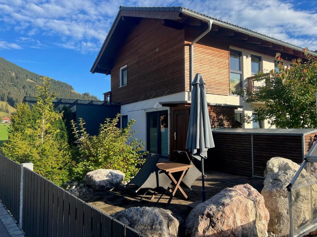 eine Terrasse mit einem Sonnenschirm, einem Stuhl und einem Haus in der Unterkunft Ferienwohnung Biermann in Oberammergau