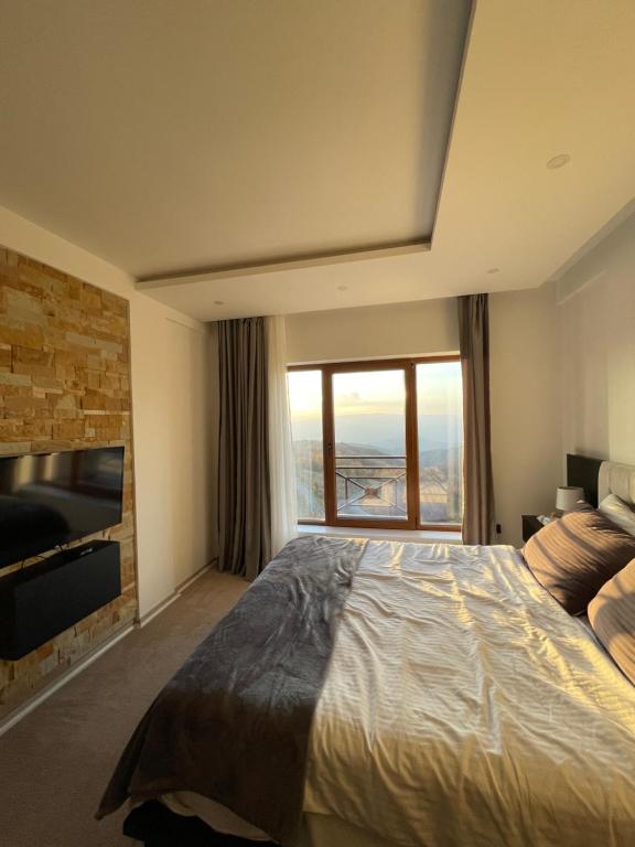 una camera con un grande letto e una grande finestra di Milmari N66 a Kopaonik