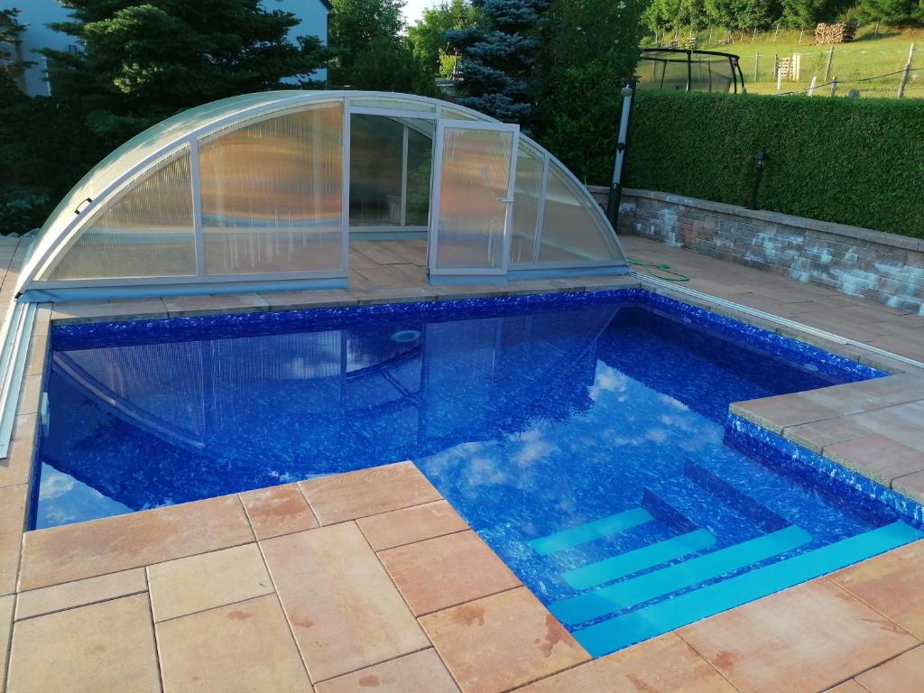 - une piscine avec un igloo et une piscine dans l'établissement Apartmány Dana, à Horní Branná