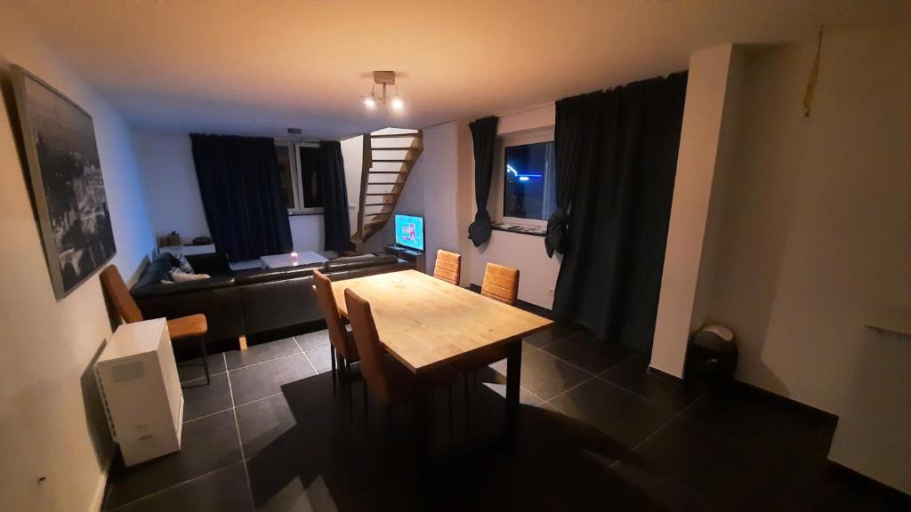 een woonkamer met een houten tafel en stoelen bij Appartement Duplex pour 3-4 personnes à Ciney in Ciney