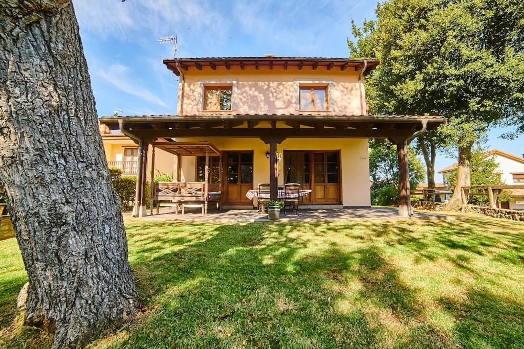 a house with a large yard with a tree at Casa rural en plena naturaleza, playa, senderismo in Villahormes