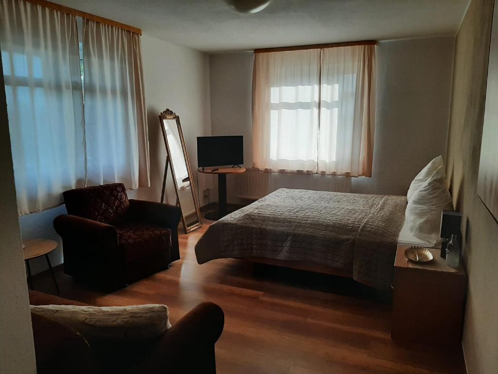 ein Hotelzimmer mit einem Bett und einem Stuhl in der Unterkunft Altes Bootshaus in Torgau