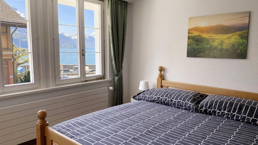 a bedroom with a bed and a large window at Holiday Apartments Falke in Brienz