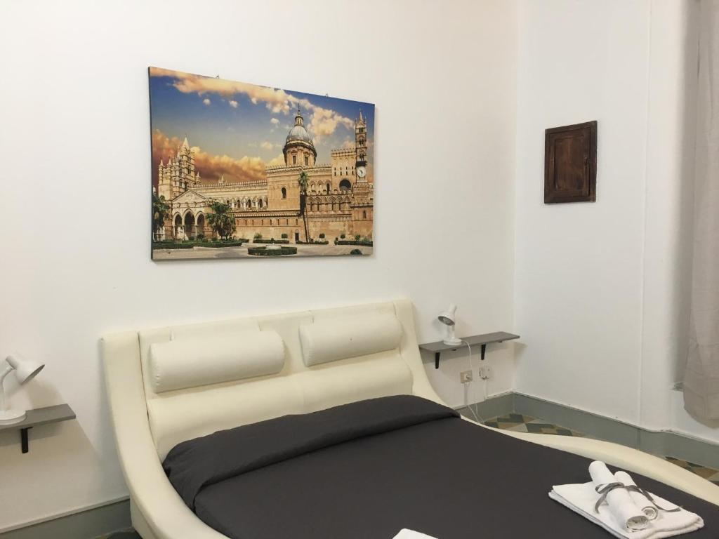 a room with a bed with a picture on the wall at Le stanze di Regina Margherita in Palermo