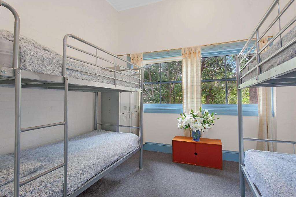 a bedroom with two bunk beds and a window at PodBed Sydney in Sydney