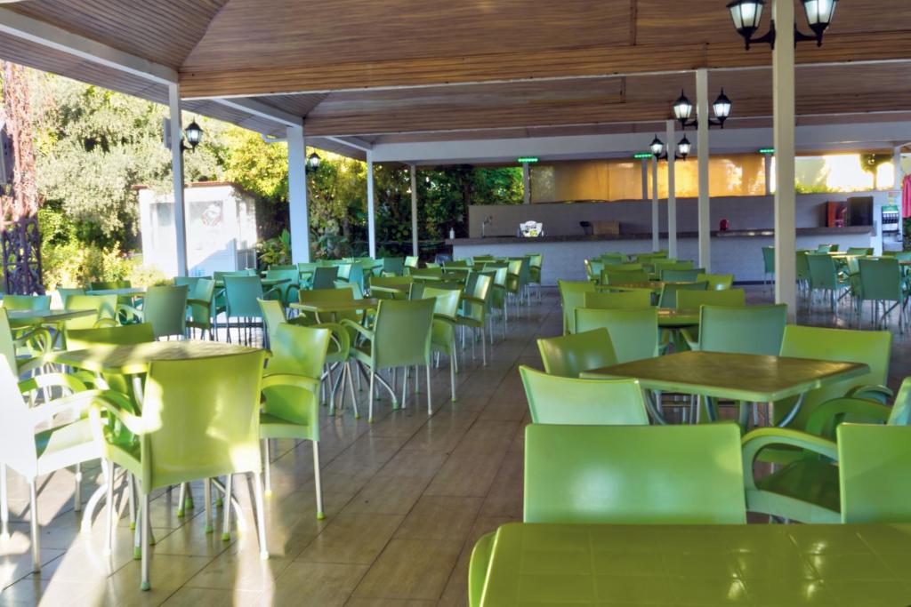 a restaurant with green chairs and tables at Blue Fish Hotel in Konaklı