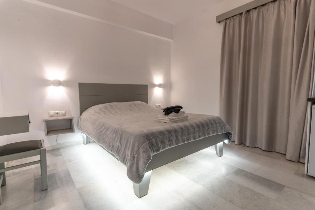 a bedroom with a bed with a cat on top of it at Alpha Studios (Adults Only) in Naxos Chora