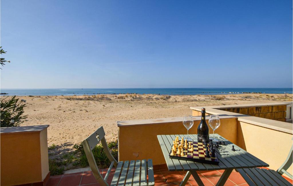 - une table avec deux verres de vin et une plage dans l'établissement Cozy Apartment In Donnalucata With Kitchen, à Donnalucata